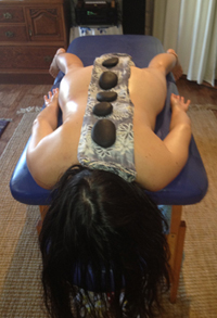 Woman relaxing with hot stones placed on her back