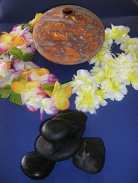 Photo of leis surrounding a vase and hot stones